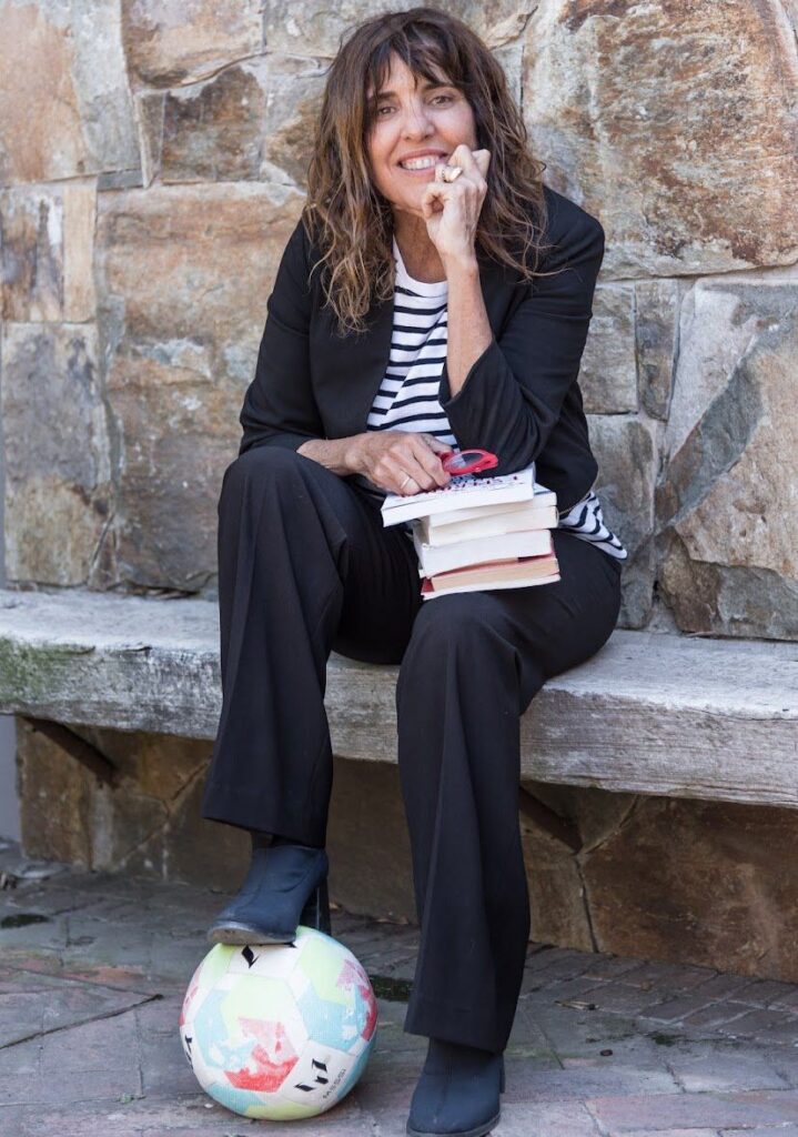 Directora ejecutiva de Educere pisando con uno de sus pies una pelota de fútbol.
Mundial y Educación.