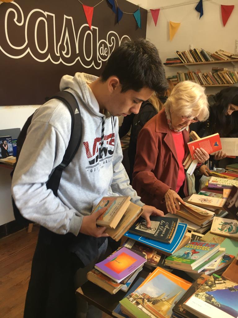 Personas mirando libros en la sede de la ONG Casa de 20